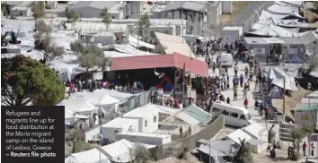  ?? — Reuters file photo ?? Refugees and migrants line up for food distributi­on at the Moria migrant camp on the island of Lesbos, Greece.