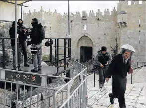  ?? Picture: AFP ?? TINDER BOX: An ultra-Orthodox Jew walks past Israeli security forces standing guard outside Damascus Gate in Jerusalem's old city yesterday