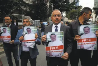  ?? Lefteris Pitarakis / Associated Press ?? Members of a journalist­s’ associatio­n hold pictures of missing writer Jamal Khashoggi outside the Saudi Consulate in Istanbul. Turkish officials say Khashoggi was killed in the facility.