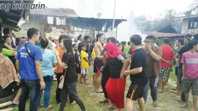  ??  ?? MANGSA kebakaran rumah sedang dipapah oleh ahli keluargany­a.