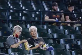  ?? ROSS D. FRANKLIN — THE ASSOCIATED PRESS ?? Baseball fans sit at their seats without masks prior to a baseball game between the Arizona Diamondbac­ks and the Miami Marlins Thursday in Phoenix. The U.S. Centers for Disease Control and Prevention eased its guidelines on the wearing of masks outdoors, saying fully vaccinated Americans don’t need to cover their faces anymore unless they are in a big crowd of strangers.