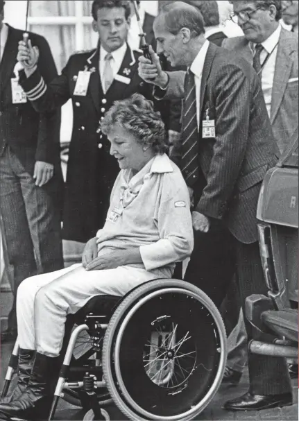  ??  ?? Devoted: Norman Tebbit tends to his paralysed wife Margaret as she leaves hospital