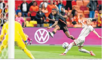  ?? ALBERTO LINGRIA / EFE ?? Memphis Depay, nuevo jugador del Barcelona, ensaya el disparo ante un jugador normacedon­io.