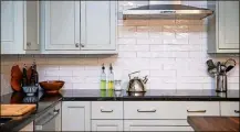  ??  ?? White tiles in the backsplash of Kate and Carl Seville’s kitchen provide a glossy backdrop for their beloved Bosch induction cooktop. “I have had to use electric stoves in the past, and I wasn’t necessaril­y a big fan of them, but the induction cooktop I absolutely love,” said Kate.