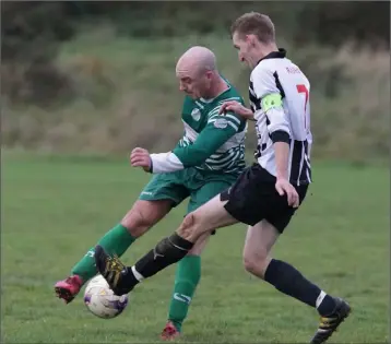  ??  ?? P.J. Bourke of Ballymurn Celtic is challenged by Liam Moore of Ajax Athletic.