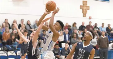  ?? GLENN MILLER /CAPITAL GAZETTE ?? Jacob Aryee of St. Mary’s goes up for a shot against Key’s Marshall Tanz while Elijah Jenkins looks on.