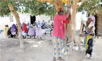  ??  ?? KODJAN: Two women pound grain as other villagers gather in Kodjan, some 60 kilometers west of Bamako. The village of some 2000 inhabitant­s has seen many of its youth leave to seek their fortunes in Europe and to help those left behind financiall­y. — AFP