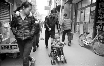  ?? AFP photos ?? Strolling on a street in the Heiqiaocun migrant village. China’s capital relies on migrant labour to keep its economy humming and people from across the country are drawn to the city by the promise of a better life. —