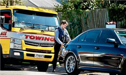  ?? LAWRENCE SMITH/STUFF ?? Police getting ready to tow a black BMW, believed to be involved in the incident, on Saturday.