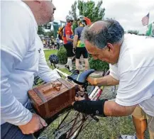  ??  ?? Gregg Blanchard, left, helps his brother-in-law, Michael Guillory, attach the cremation box of Keri Guillory to a bike.