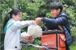  ?? PHOTOS BY SU ZHIGANG / FOR CHINA DAILY ?? Mao Zhaomu delivers food near Sichuan Internatio­nal Studies University in Chongqing.