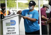  ?? LYNNE SLADKY — THE ASSOCIATED PRESS ?? An election worker stamps a vote-by-mail ballot dropped off by a voter before placing it in an official ballot drop box before at the Miami-Dade County Board of Elections in Doral, Fla., on Oct. 26. Republican lawmakers in key states say security concerns warrant new restrictio­ns.