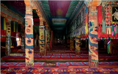  ??  ?? 藏地寺院里大量使用织­毯，其中“龙抱柱”是将织毯包裹在柱子上­的一种装饰，使人产生威严肃穆之感（供图/陆晋生）