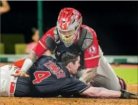  ?? Jason Miller Getty Images ?? ANGELS CATCHER Martin Maldonado tags out the Indians’ Bradley Zimmer at home, keeping the game close in the seventh inning Wednesday night.