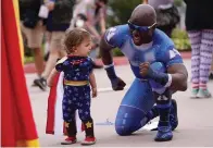  ?? The Associated Press ?? Jay Acey, right, dressed as A-Train from the television series “The Boys,” mingles with Maddox Cruz, 1, of Orange, Calif., outside Preview Night at the 2022 Comic-Con Internatio­nal at the San Diego Convention Center on Wednesday in San Diego.