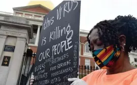  ??  ?? PRAYERS OFFERED: Alice Gaskins of Boston prays with others while protesting the way little has been done to get to the root of why blacks seem disproport­ionately struck by the coronaviru­s.