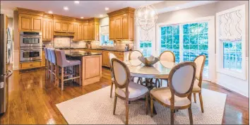  ?? Photos by C. Saelens Photograph­y ?? Above: The eat-in kitchen includes a dining area with a symmetrica­l modern chandelier and sliders that open to a deck. Below: The completely updated colonial at 35 Block Farm Road is on 0.76 park-like acres.