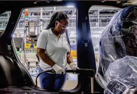  ??  ?? Left: Inconspicu­ous mechanical platforms assist the installati­on of all four doors. Top: Using a computeris­ed wrench, a worker calculates the number of revolution­s and the amount of torque applied to the bolts of the rear seat.