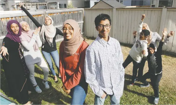  ?? BRENDAN MILLER ?? 2020 graduates Israa and Amar Hassan, centre, celebrate with siblings, from left, Ronissaa, Omimah, Sara, Adnan, Imran and mother Naima Ait Lahsen in their backyard. Both Israa and Amar are planning different ways to mark their graduation­s. Israa was named valedictor­ian for Lester Pearson High and Amar is graduating from Nelson Mandela High School.