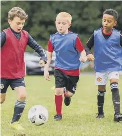  ??  ?? GETTING STUCK IN: Youngsters at the football school.