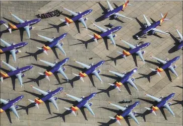  ?? Mario Tama Getty Images ?? SOUTHWEST AIRLINES 737 Max jets are parked at a logistics airport in Victorvill­e, Calif. Boeing’s reputation and finances have been battered since two crashes killed 346 people and prompted a global grounding.