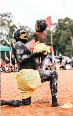  ??  ?? CLOCKWISE FROM LEFT: A young Garma-goer gets into the spirit; Russell Gurruwiwi with toddler Joevhan Burarrwang­a; Gumatj women dancing; Joevhan Burarrwang­a, the next generation of the Yolngu.