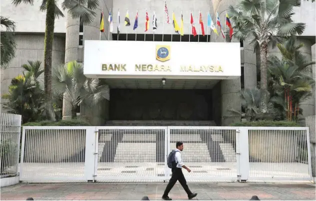  ?? Reuters ?? ±
A man walks past the entrance of Central Bank of Malaysia in Kuala Lumpur, Malaysia.