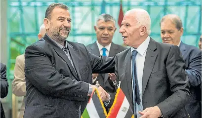  ?? AFP ?? Negociador­es. Azam al-Ahmad de Al Fatah (der.) y Saleh al-Aruri de Hamas se saludan tras el acuerdo.