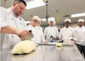  ??  ?? Chef Jason Stricker, left, helps divide dough for students during his baking class at Valencia College in 2016.