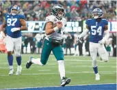  ?? AL BELLO/GETTY ?? Quarterbac­k Jalen Hurts runs for a touchdown during the Eagles’ 48-22 win over the Giants on Sunday.