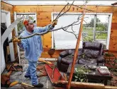  ?? ANDY JACOBSOHN / DALLAS MORNING NEWS ?? Andy Teague cleans up his home Sunday in Fruitvale after a tornado struck. The family sheltered in a shower.