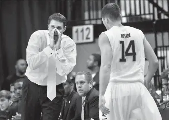  ?? Staff Photo by Doug Strickland ?? UTC men's basketball coach Will Wade directs guard Alex Bran (14) during the Mocs' basketball game
up-tempo “Chaos” style of play.