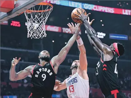  ?? Harry How Getty Images ?? CLIPPERS CENTER Marcin Gortat goes up for a rebound between Toronto’s Serge Ibaka (9) and Pascal Siakam during the first half at Staples Center. Ibaka had 25 points and nine rebounds, and Siakam had a plus-29 in the Raptors’ romp.