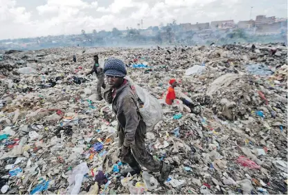  ?? BEN CURTIS, AP ?? A man scavenges for pieces of plastic for a living at the dump in the Dandora slum of Nairobi, Kenya.