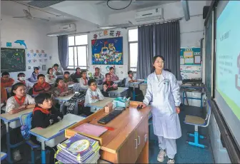  ?? XU YU / XINHUA ?? Above: A mental health doctor gives a lecture to primary school students in Donglin town of Huzhou, Zhejiang province, in November.