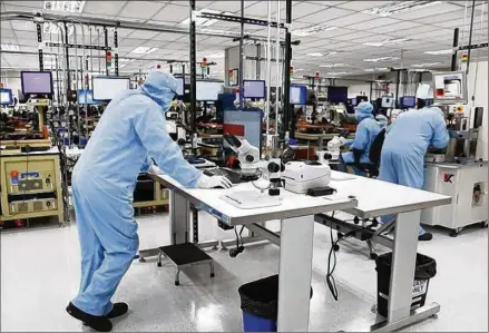  ?? ROSE BACA / DALLAS MORNING NEWS ?? Employees work at a Finisar manufactur­ing lab in Allen. The California company is opening another, larger plant in Sherman this year to make vertical-cavity surface-emitting lasers for Apple’s iPhone X.