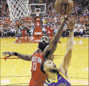  ?? Eric Christian Smith The Associated Press ?? Rockets guard James Harden, rear, and Warriors guard Stephen Curry vie for a firsthalf rebound Saturday in Houston’s 126-121 overtime win at the Toyota Center.