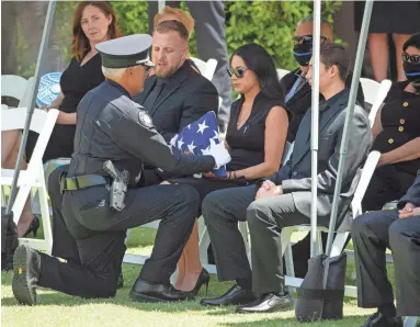  ?? ROB SCHUMACHER/THE REPUBLIC ?? Peoria police Chief Art Miller presents a flag to Teresa Judd, widow of Officer Jason Judd.