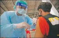  ?? (AP/Sakchai Lalit) ?? A health worker administer­s a dose of the Sinovac covid-19 vaccine to residents of a popular market area where a new cluster of covid-19 infections was found in Bangkok.