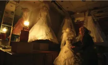  ?? MAHMUD HAMS/AFP/GETTY IMAGES FILE PHOTO ?? A Palestinia­n woman looks at wedding dresses in a Gaza City shop. A Canadian woman named “Z.” in court documents married her husband in the Gaza Strip in 1992 and left him in 2013 after years of alleged abuse.