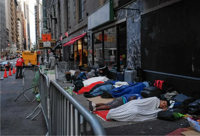  ?? TODD HEISLER/NEW YORK TIMES ?? Newly arrived migrants slept in a queue outside the Roosevelt Hotel in midtown Manhattan in August.