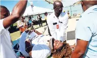  ??  ?? Paramedics transporti­ng one of the ‘injured persons’ during the Water and Aviation Emergency Simulation at the Norman Manley Internatio­nal Airport last Thursday.