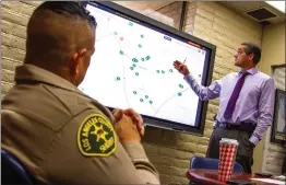  ?? Austin Dave/The Signal ?? Lt. Ignacio Somano, right, explains a crime trend of vehicle thefts over the last week using a SMART Board as Capt. Robert Lewis looks on.