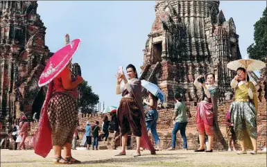  ?? UARAWEE KITTISILPA / REUTERS ?? People dressed in traditiona­l costumes pose for a picture, as interest for historical clothing rises within the country, in Ayutthaya, Thailand,
on Friday.