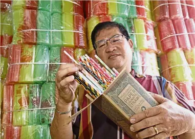  ??  ?? Eco-friendly alternativ­e: Pusat Plastik Guan Seng Heng Sdn Bhd owner Michael Loh Boon Huat showing a box of waxcoated paper straws at his shop in Presgrave Street, George Town.