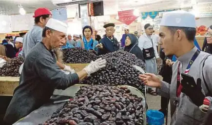  ??  ?? PENJUAL kurma berhampira­n ladang fasih berbahasa Melayu dan jemaah tiada masalah membeli atau tawar menawar.