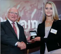  ??  ?? President Michael D Higgins presenting Hannah Johnston with her Gaisce Gold Award.