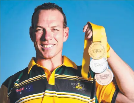  ?? IMPRESSIVE HAUL: Townsville's Peter Brown with his Invictus Games gold, silver and bronze rowing medals. Picture: ALIX SWEENEY ??