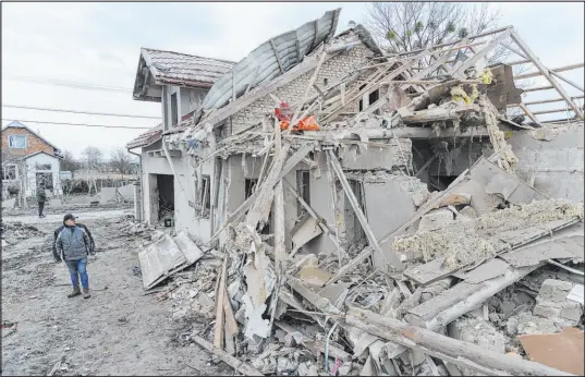  ?? Mykola Tys The Associated Press ?? A villager passes by debris of private houses ruined by Russia’s rocket attack Thursday in a village in Ukraine’s Lviv region.