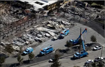  ?? AP PHOTO/MARCIO JOSE SANCHEz ?? in this 2017 file photo Pacific Gas &amp; Electric crews work on restoring power lines in a fire ravaged neighborho­od in an aerial view in the aftermath of a wildfire in Santa Rosa, Calif.